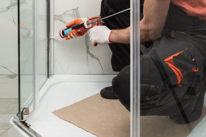 Worker measuring plastic window indoors. Installation process